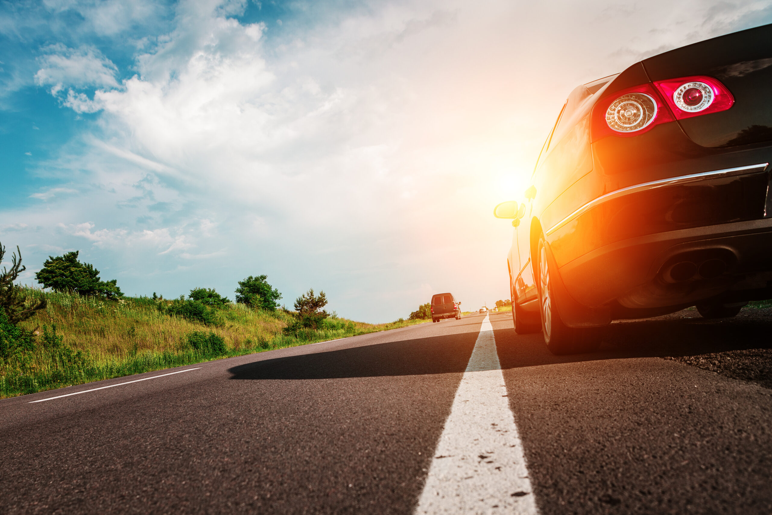 black car on asphalt road sun