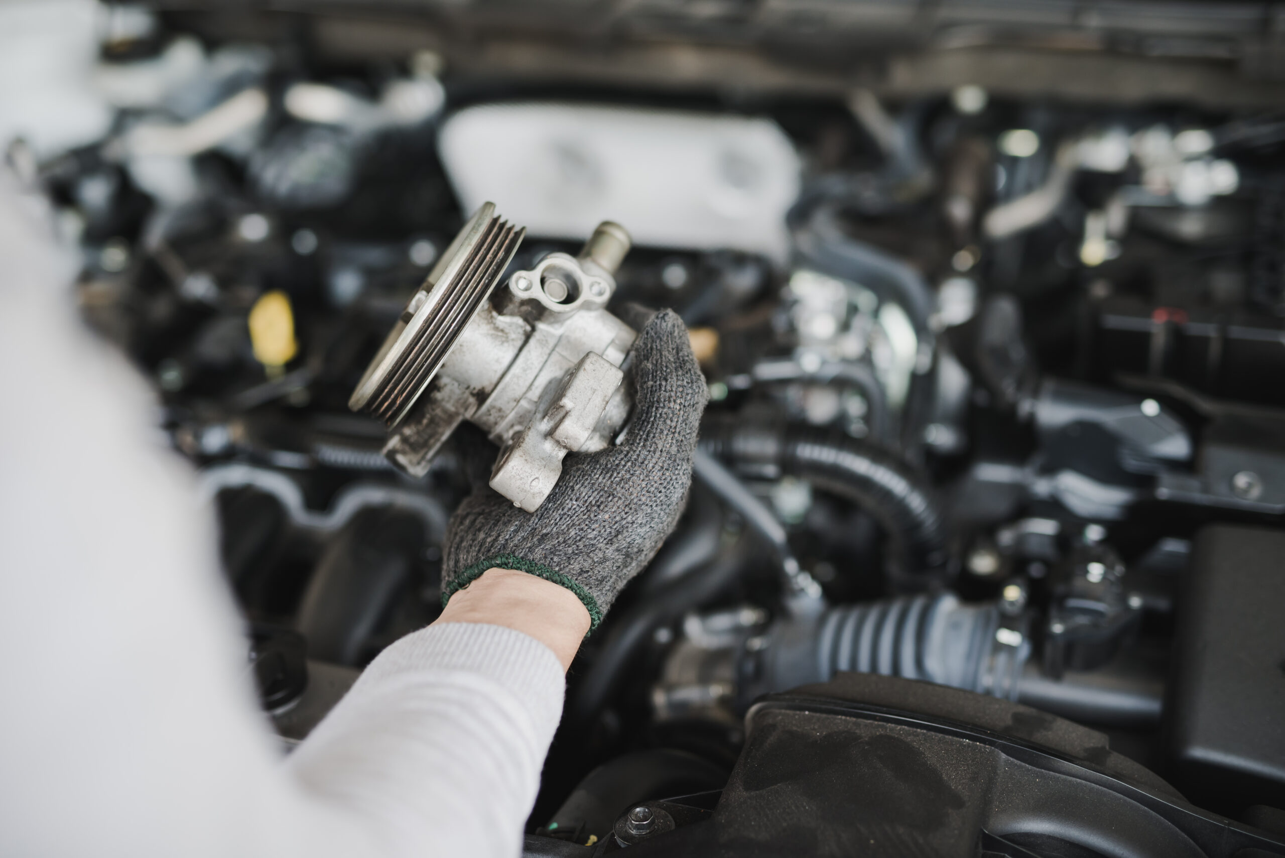 Hand of car mechanic with spare parts at service center repair