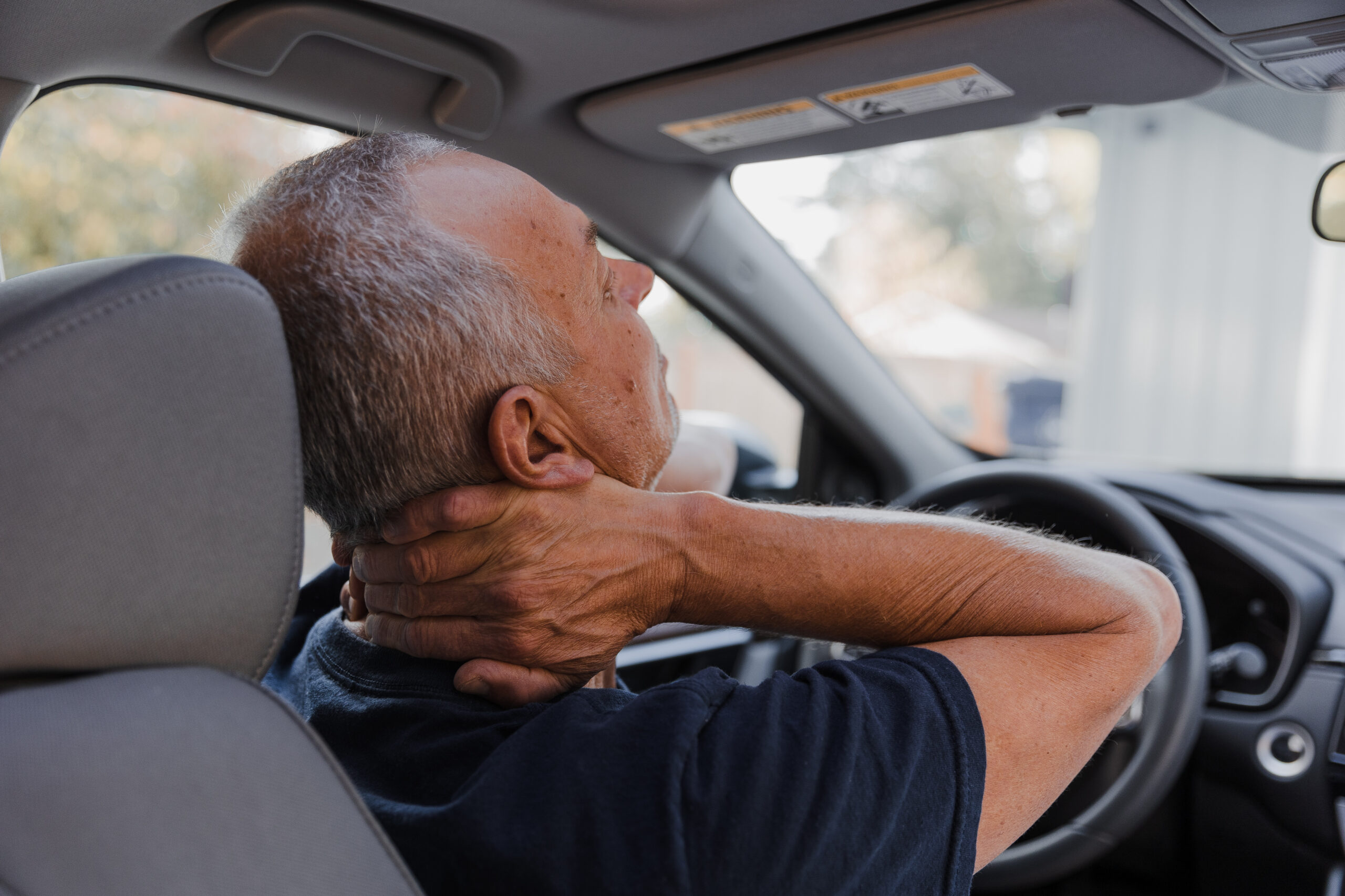 Middle-aged man with neck pain in car